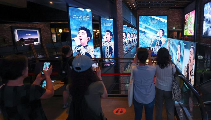 22일 오후 서울 CGV 용산아이파크몰을 찾은 시민들이 ‘임영웅│아임 히어로 더 스타디움’ 광고 영상을 스마트폰으로 촬영하는 모습. /사진=뉴스1