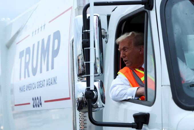 10월 30일(현지시간) 미국 공화당 대선후보 도널드 트럼프 전 대통령이 위스콘신주 그린베이에서 그의 이름과 선거 구호인 '미국을 다시 위대하게'가 적힌 쓰레기 트럭 운전석에 앉아 있다./로이터=뉴스1