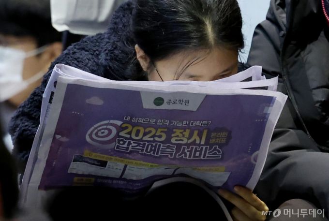 [서울=뉴시스] 이영환 기자 = 8일 오후 서울 종로구 성균관대학교 600주년기념관 새천년홀에서 종로학원이 주최한 실채점 결과 토대 2025 정시 합격가능선 예측 및 전략 설명회에서 참석자들이 배치표를 살펴보고 있다. 2024.12.08.  /사진=이영환