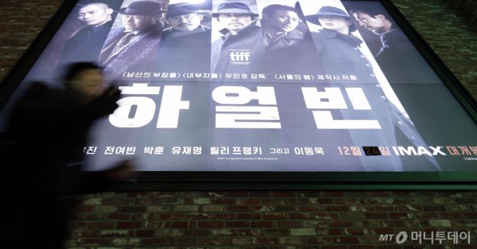 24일 서울 CGV용산아이파크몰에서 영화 관람객이 '하얼빈' 홍보 스크린 앞을 지나가고 있다.   영화관입장권 통합전산망에 따르면 영화 '하얼빈'이 총예매량 56만 2847장으로 예매율 1위를 기록하며 개봉했다. /사진=최동준