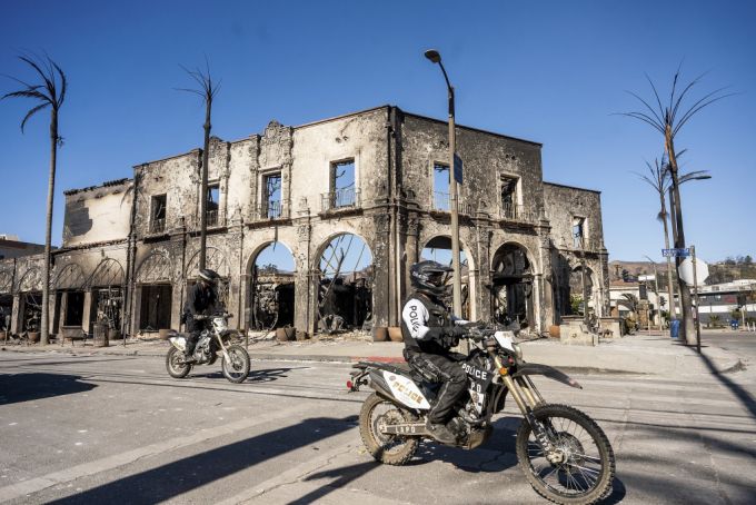 12일(현지 시간) 미 캘리포니아주 로스앤젤레스 인근 퍼시픽 팰리세이즈에서 오토바이를 탄 경찰관이 '팰리세이즈 파이어' 산불로 파괴된 상가 앞을 지나가고 있다. /AP=뉴시스