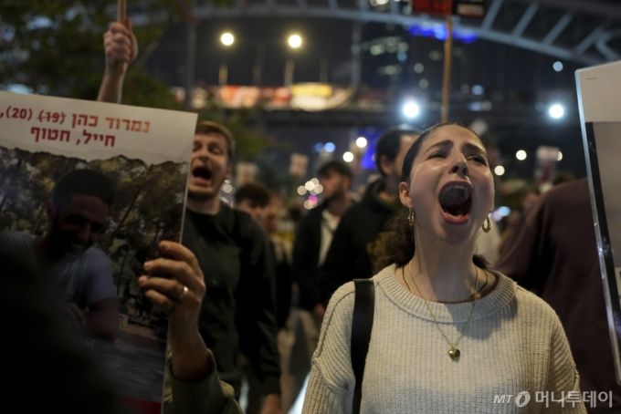 15일(현지 시간) 이스라엘 텔아비브에서 인질 석방 촉구 시위를 벌이던 인질의 가족과 그 지지자들이 휴전 발표에 반응하고 있다. 이스라엘과 하마스가 가자지구 전쟁 15개월 만에 휴전 및 인질 석방에 전격 합의했다고 중재국인 미국과 카타르가 공식 발표했다. 휴전은 도널드 트럼프 미국 대통령 당선인 취임 하루 전인 19일부터 단계적으로 발효될 것으로 알려졌다./AP=뉴시스