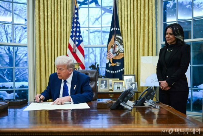 (워싱턴 AFP=뉴스1) 우동명 기자 = 도널드 트럼프 미국 대통령이 11일(현지시간) 워싱턴 백악관에서 열린 털시 개버드 국가정보국(DNI) 국장의 취임식서 임명장에 서명을 하고 있다. 2025.02.13  ⓒ AFP=뉴스1  Copyright (C) 뉴스1. All rights reserved. 무단 전재 및 재배포,  AI학습 이용 금지. /사진=(워싱턴 AFP=뉴스1) 우동명 기자