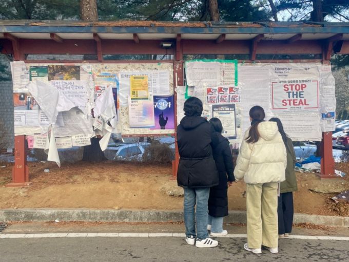 14일 서울대 법학전문대학교 앞에서 학생들이 탄핵 찬반 대자보로 뒤엉킨 게시판을 보고 있다. /사진=이현수 기자.