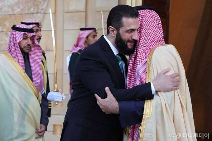 (리야드 AFP=뉴스1) 우동명 기자 = 무함마드 빈 살만 사우디아라비아 왕세자가 2일(현지 시간) 리야드를 방문한 아메드 알샤라 시리아 임시 대통령과 만나 포옹을 하고 있다. 2025.02.03  ⓒ AFP=뉴스1  Copyright (C) 뉴스1. All rights reserved. 무단 전재 및 재배포,  AI학습 이용 금지. /사진=(리야드 AFP=뉴스1) 우동명 기자