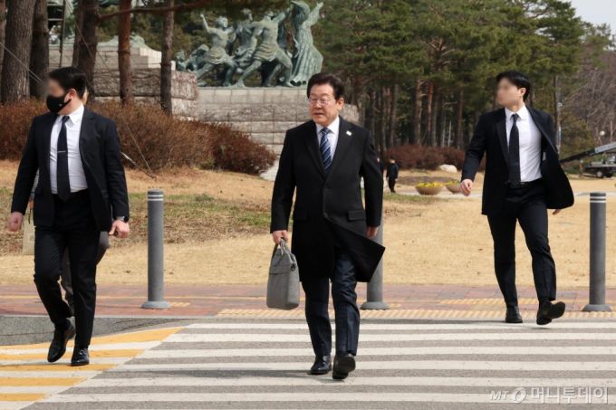 암살 위협설이 제기된 이재명(가운데) 더불어민주당 대표가 17일 서울 여의도 국회에서 최고위원회의와 비상의원총회에 참석한 뒤 경호원의 보호를 받으며 이동하고 있다.  경찰은 이날 오전 서울 서대문구 경찰청에서 열린 정례 브리핑에서 암살 위협설이 제기된 이 대표에 대한 신변 보호 조치를 당과 협의 중이라고 밝혔다. / 사진제공=뉴시스