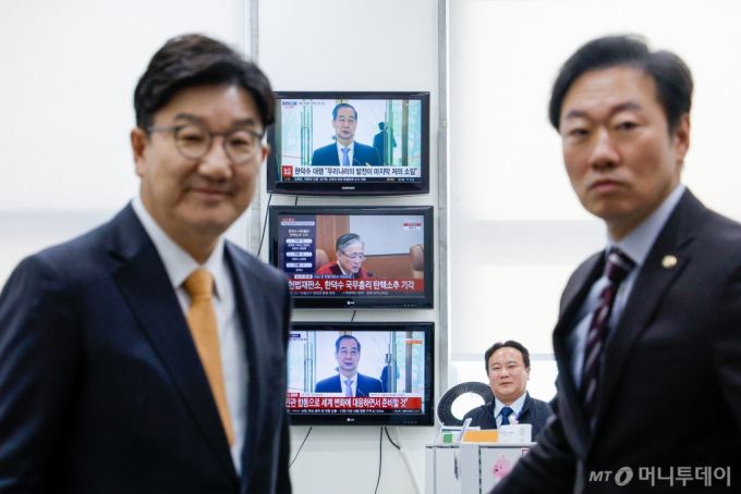 권성동 국민의힘 원내대표가 24일 서울 여의도 국회에서 헌법재판소의 한덕수 국무총리 탄핵소추 기각 판결 관련 기자회견을 하기 위해 원내대표실에서 나오는 가운데 벽에 걸린 TV 화면에 한 총리의 직무복귀 입장발표 생중계 뉴스 화면이 나오고 있다. 오른쪽은 박수민 원내대변인. 2025.3.24/사진=뉴스1 /사진=(서울=뉴스1) 안은나 기자