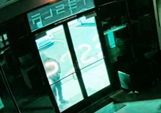 지난 18일(현지시간) 새벽 2시45분쯤 미국 라스베이거스의 테슬라 서비스 센터에서 벌어진 테러에 앞서 용의자가 센터 현관에 '저항하라(Resis)' 문구를 스프레이로 쓰는 장면/사진=CNBC뉴스 캡쳐