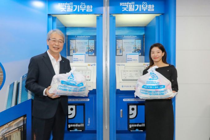 임종룡 우리금융그룹 회장과 고객 대표가 굿윌기부함에 1호 기부를 하고 있다./사진제공=우리금융그룹