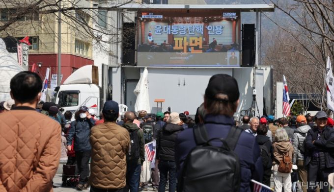 (서울=뉴스1) 장수영 기자 = 윤석열 대통령 탄핵심판 선고일인 4일 서울 중구 세종대로사거리에서 탄핵 반대 집회 참석자들이 헌법재판소의 대통령 파면 인용 생중계를 시청하고 있다.   이날 헌법재판소는 재판관 전원 일치 의견으로 윤 대통령 파면을 결정했다. 2025.4.4/뉴스1  Copyright (C) 뉴스1. All rights reserved. 무단 전재 및 재배포,  AI학습 이용 금지. /사진=(서울=뉴스1) 장수영 기자