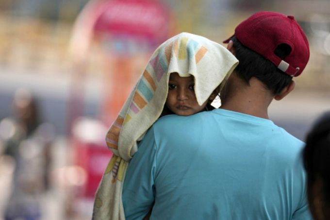 지난해 여름 인도 잠무에서 한 남성이 폭염으로부터 아기를 보호하기 위해 수건으로 아기 머리를 가려놓은 모습. /AP=뉴시스