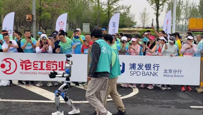 '기록은 뒷전' 인간 마라토너들이 달리기를 멈추고 휴머노이드로봇이 주로를 달리는 모습을 촬영하고 있다./사진=우경희 기자