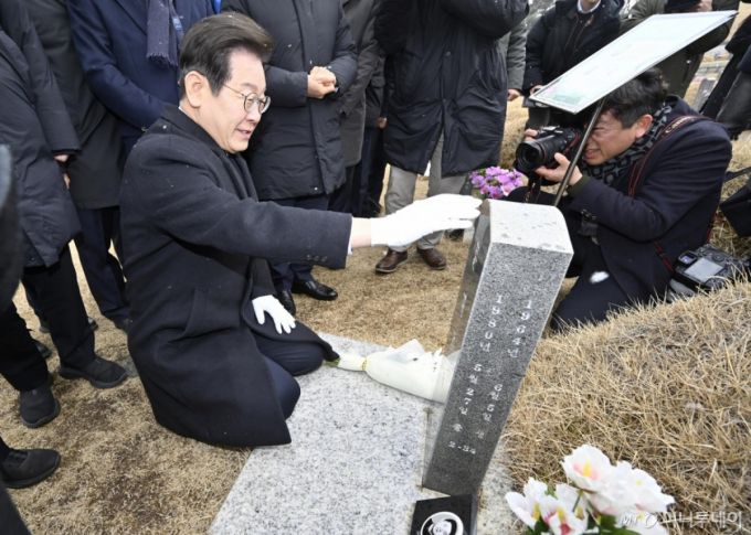 [광주=뉴시스] 박기웅 기자 = 이재명 더불어민주당 대표가 18일 오후 광주 북구 운정동 국립5·18민주묘지를 방문, 한강 작가의 소설 '소년의 온다'의 주인공 고 문재학 열사 묘지에서 참배하고 있다. 2025.03.18. pboxer@newsis.com /사진=