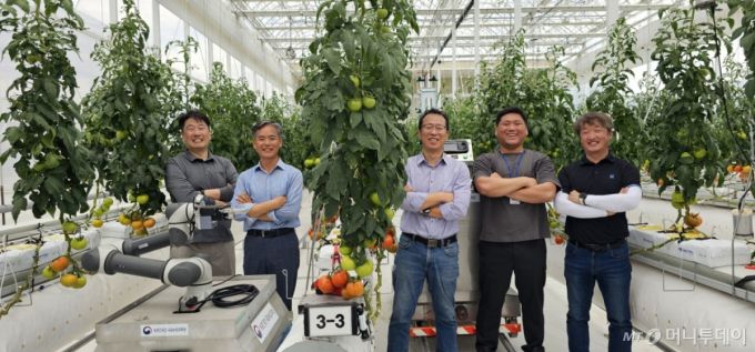 국립농업과학원 이충근 농업로봇과장(사진 왼쪽 두번째)이 22일 우리 기술로 직접 개발한 모니터링 로봇, 운반 로봇 앞에서 홍영기 농업연구관(왼쪽 세번째), 김국환 농업연구관(왼쪽 다섯번째), 김경철 농업연구사(왼쪽 첫번째) 등 연구진과 함께 활짝 웃고 있다. /사진=정혁수