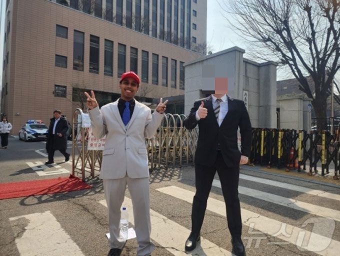 지난달 7일 서울시 마포구 서부지법에서 업무방해 및 경범죄처벌 위반 혐의로 기소된 미국인 유튜버가 첫 공판 후 손가락으로 브이자를 그리고 있다. /사진=뉴스1