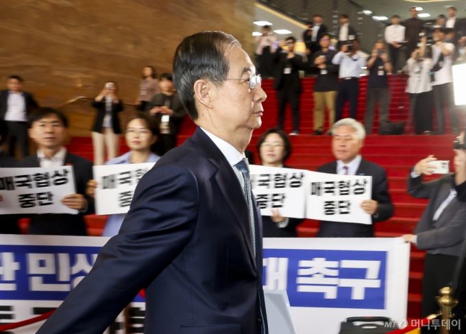 한덕수 대통령 권한대행 국무총리가 24일 서울 여의도 국회에서 열린 본회의에서 2025년도제1회추가경정예산안에대한정부의시정연설을 위해 국회 본청으로 들어서고 있다. 한 대행 뒤로 야4당(조국혁신당, 진보당, 기본소득당, 사회민주당) 의원들이 한 대행을 규탄하는 피켓을 들고 있다. 2025.04.24. /사진=뉴시스 /사진=