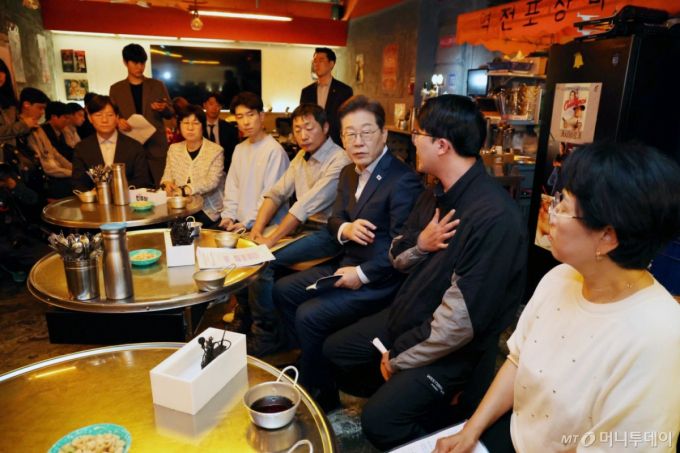 [서울=뉴시스] 조성우 기자 = 이재명 더불어민주당 대선후보가 1일 오후 서울 종로구의 한 포장마차에서 배달라이더, 택배기사 등 비(非)전형 노동자들과 간담회를 하고 있다. (공동취재) 2025.05.01. photo@newsis.com /사진=