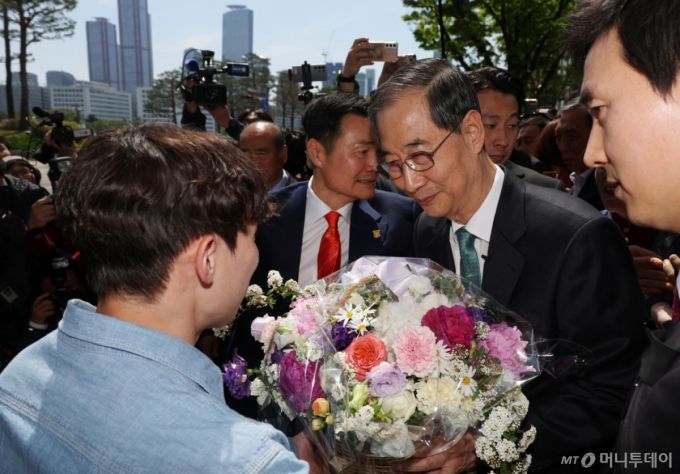 한덕수 전 국무총리가 2일 서울 여의도 국회 소통관에서 대선 출마 기자회견을 마친 뒤 건물을 나서던 중 한 청년으로부터 꽃을 받고 있다. 2025.05.02. /사진=뉴시스 /사진=고승민