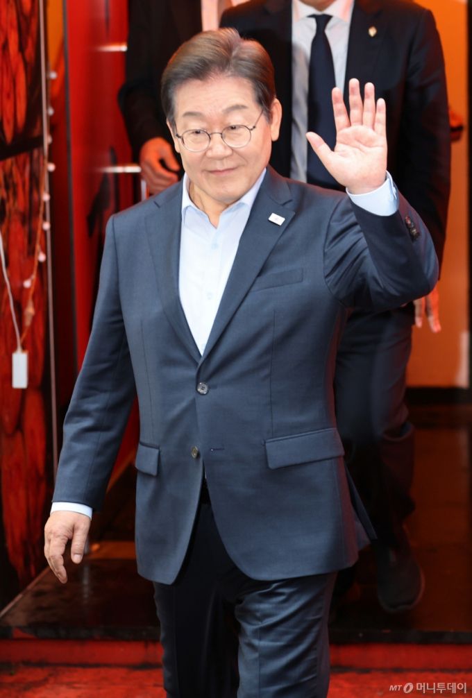 (서울=뉴스1) 이재명 기자 = 이재명 더불어민주당 대통령 후보가 1일 서울 종로구의 한 포차 식당에서 '당신의 하루를 만드는, 보이지 않는 영웅들'이란 주제로 열린 배달 라이더, 택배 기사 등 비(非)전형 노동자들과 간담회를 마친 뒤 나서며 손인사를 하고 있다. (공동취재) 2025.5.1/뉴스1  Copyright (C) 뉴스1. All rights reserved. 무단 전재 및 재배포,  AI학습 이용 금지. /사진=(서울=뉴스1) 이재명 기자