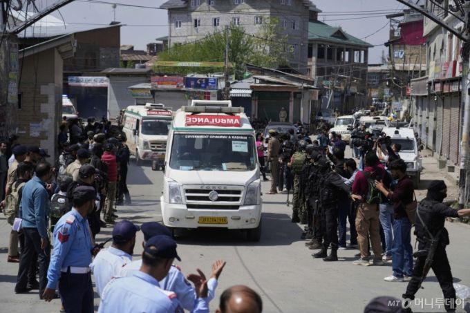 Police guard as ambulances carry bodies of tourists, in Srinagar, Indian controlled Kashmir, Wednesday, April. 23, 2025. (AP Photo/Mukhtar Khan)