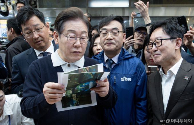 (단양=뉴스1) 이재명 기자 = '골목골목 경청투어 : 단양팔경편'에 나선 이재명 더불어민주당 대통령 후보가 4일 오전 충북 단양군 단양구경시장에서 상인이 건네 준 편지를 읽어보고 있다. 2025.5.4/뉴스1  Copyright (C) 뉴스1. All rights reserved. 무단 전재 및 재배포,  AI학습 이용 금지. /사진=(단양=뉴스1) 이재명 기자