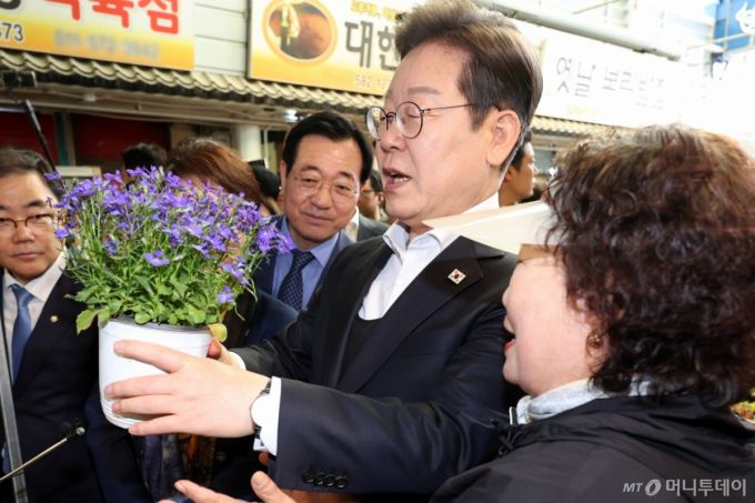 [함안=뉴시스] 조성우 기자 = 민심을 청취하는 '경청 투어'에 나선 이재명 더불어민주당 대선후보가 10일 경남 함안군 가야시장에서 화분을 보고 있다. 2025.05.10. xconfind@newsis.com /사진=조성우