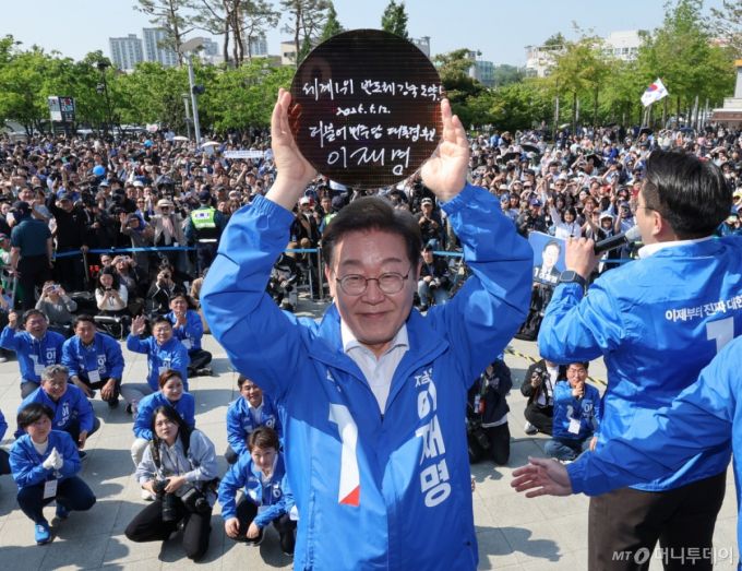 이재명 더불어민주당 대통령 후보가 제21대 대통령 선거 공식 선거운동 첫날인 12일 오후 경기 화성시 동탄 센트럴파크 음악분수중앙광장에서 '세계 1위 반도체 강국 도약!'이라고 쓴 반도체 웨이퍼를 들어 보이고 있다. 2025.5.12/사진=뉴스1 /사진=(화성=뉴스1) 안은나 기자