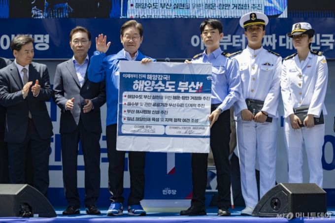 [부산=뉴시스] 권창회 기자 = 이재명 더불어민주당 대선 후보가 14일부산 부산진구 서면 젊음의 거리에서 열린 유세에서 권기흥 에이치라인해운해상직원노조 위원장과 해양수도 부산 협약서에 서명한 뒤 기념촬영을 하고 있다. (공동취재) 2025.05.14.