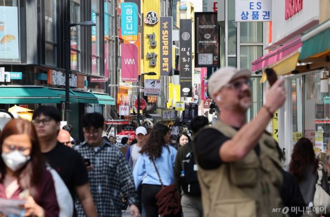 (서울=뉴스1) 장수영 기자 = 11일 서울 중구 명동거리를 찾은 관광객들이 상점 앞을 지나고 있다.  기획재정부는 이날 4월 최근 경제동향(그린북)을 발표하면서 내수 회복 지연과 미국의 상호 관세 부과 등의 여파로 경기 하방 압력이 증가하고 있다고 분석했다. 2025.4.11/뉴스1