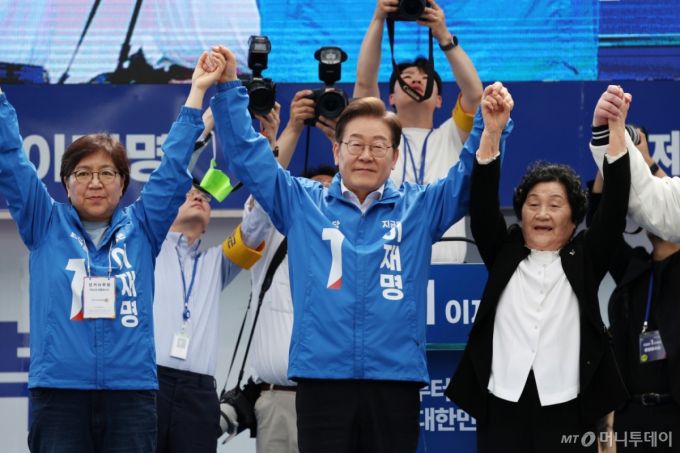 (광주=뉴스1) 이재명 기자 = 이재명(가운데) 더불어민주당 대통령 후보가 17일 광주 서구 김대중컨벤션센터 광장에서 열린 집중유세에서 정은경(왼쪽) 총괄선대위원장, '고교생 5·18시민군' 고(故) 문재학 열사의 어머니 김길자 여사의 손을 잡고 시민들에게 인사하고 있다.(공동취재)2025.5.17/뉴스1  Copyright (C) 뉴스1. All rights reserved. 무단 전재 및 재배포,  AI학습 이용 금지. /사진=(광주=뉴스1) 이재명 기자