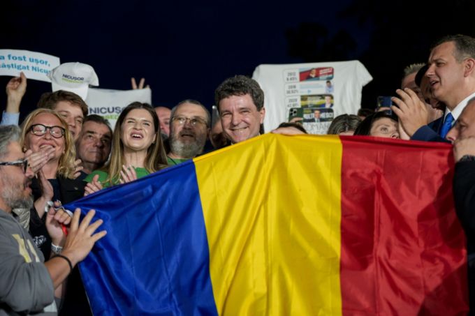 니쿠쇼르 단 루마니아 대선 후보가 18일(현지 시간) 부쿠레슈티에서 대선 결선 투표가 끝난 후 지지자들과 함께 국기를 들고 포즈를 취하고 있다. 친유럽연합 성향의 단 후보는 극우 민족주의 성향의 제1야당 결속동맹(AUR) 대표 제오르제 시미온 후보를 따돌리고 대통령에 당선됐다. /AFPBBNews=뉴스1
