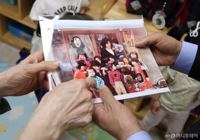 [광명=뉴시스] 고승민 기자 = 김문수 국민의힘 대선 후보와 설난영 여사가 22일 경기 광명시의 한 어린이집에서 아이들을 만나던 중 딸 동주 씨의 어린시절 사진을 보고 있다. 2025.05.22. kkssmm99@newsis.com /사진=고승민