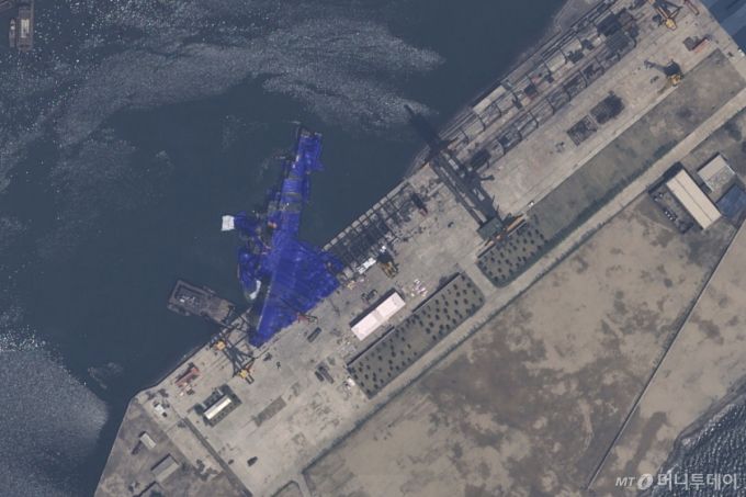 [청진=AP/뉴시스] 에어버스 DS가 제공한 22일 자 위성 사진에 북한 청진의 조선소에서 진수에 실패한 5000t 최현급 신형 구축함이 파란 방수포에 덮여 있다. 2025.05.23. /사진=민경찬