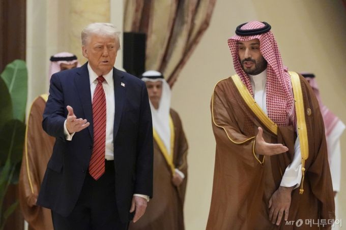 [리야드=AP/뉴시스] 도널드 트럼프(왼쪽) 미국 대통령과 무함마드 빈 살만 사우디 왕세자가 14일(현지 시간) 사우디아라비아 리야드에서 열린 걸프협력회의(GCC) 정상회의에 함께 참석해 GCC 정상들과 단체 사진 촬영장으로 향하고 있다. 2025.05.14. /사진=민경찬