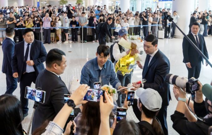 손흥민이 27일 인천국제공항을 통해 귀국해 팬에게 꽃다발을 전달받고 있다./사진=뉴시스