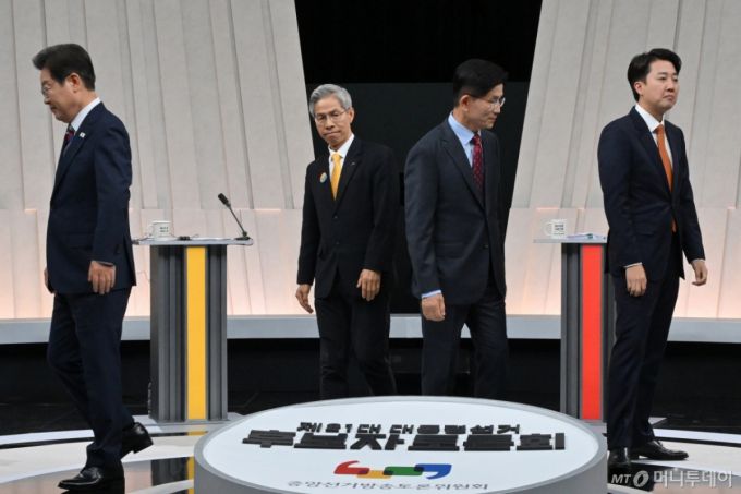 [서울=뉴시스] 국회사진기자단 = 27일 오후 서울 마포구 상암동 MBC 스튜디오에서 열린 중앙선거방송토론위원회 주관 제21대 대통령선거 3차 후보자토론회 시작에 앞서 각 정당 대선후보들이 기념촬영을 마친 뒤 자리로 돌아가고 있다. 왼쪽부터 이재명 더불어민주당, 권영국 민주노동당, 김문수 국민의힘, 이준석 개혁신당 대선후보. 2025.05.27. photo@newsis.com /사진=