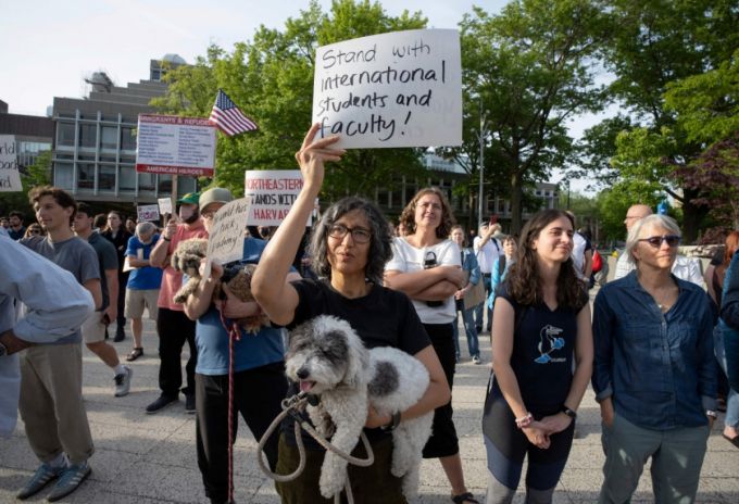 27일(현지시간) 미국 매사추세츠주(州) 보스턴에 있는 하버드 대학교 캠퍼스에서 유학생을 지지하는 집회가 열렸다. 한 집회 참여자가 '국제 유학생과 교수진과 함께한다'는 플래카드를 들고 있는 모습. /AFPBBNews=뉴스1