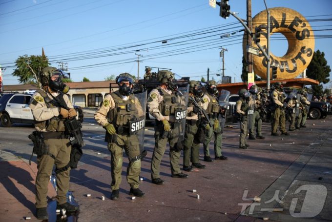 미국 이민세관단속국(ICE)이 7일(현지시간) 이틀째 로스앤젤레스(LA)에서 불법 체류자 단속을 시작한 가운데 시위대가 격렬하게 대응하고 있다. 사진은 시위대와 대치하고 있는 대원들의 모습. 2025.6.7. ⓒ 로이터=뉴스1