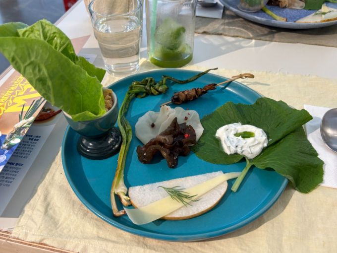 12일 진행된 NS홍쇼핑 뉴파머스레스토랑 메뉴는 로컬 식재료의 다양성과 활용도를 보여주는 데 초점을 맞췄다. 이날 제공된 코스는 로메인, 목이버섯, 표고버섯, 배, 양대파 등 국내산 제철 식재료가 중심을 이뤘으며, 이를 활용한 플레이트, 세비체, 스프, 솥밥, 디저트로 구성됐다.사진은 첫 코스로 나온 뉴파머스플레이트. /사진=하수민기자