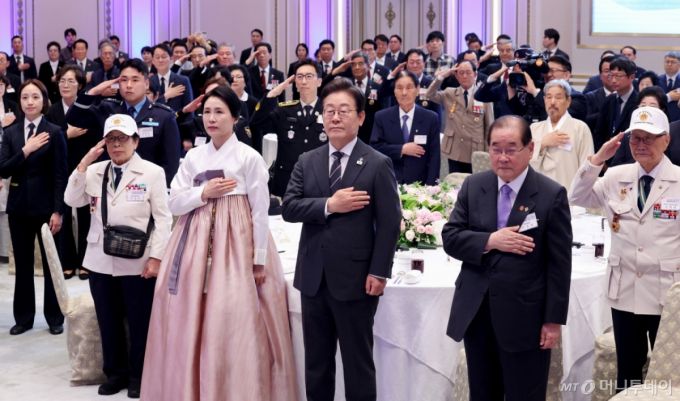 [서울=뉴시스] 최진석 기자 = 이재명 대통령과 부인 김혜경 여사가 27일 청와대 영빈관에서 열린 '호국보훈의 달, 대통령의 초대' 행사에서 국기에 경례하고 있다. (대통령실통신사진기자단) 2025.06.27. myjs@newsis.com /사진=최진석