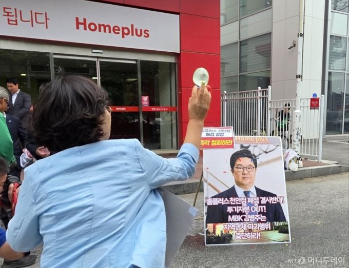 마트 노동자들이 2일 천안시 동남구 홈플러스 천안점 앞에서 열린 폐점 반대 기자회견에서 김병주 MBK파트너스 회장을 규탄하며 얼굴 사진에 물풍선을 던지고 있다. 2025.6.2/뉴스1  Copyright (C) 뉴스1. All rights reserved. 무단 전재 및 재배포,  AI학습 이용 금지. /사진=(천안=뉴스1) 이시우 기자