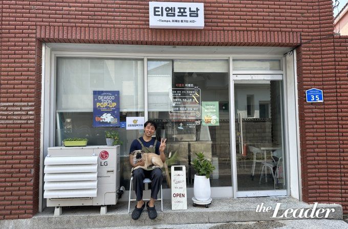▲‘강릉살자’ 11기 신재희 씨가 창업한 카페 ‘티엠포남’ 앞에서 반려견 ‘포남이’와 포즈를 취하고 있다./사진=최현승 기자