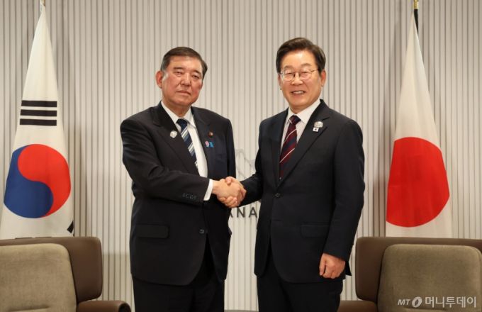 이재명 대통령이 지난달 17일(현지시간) 캐나다 앨버타주 캐내내스키스 주요 7개국(G7) 정상회의장에서 열린 한일 정상회담에서 이시바 시게루 일본 총리와 악수하며 기념촬영하고 있다. / 사진=뉴시스