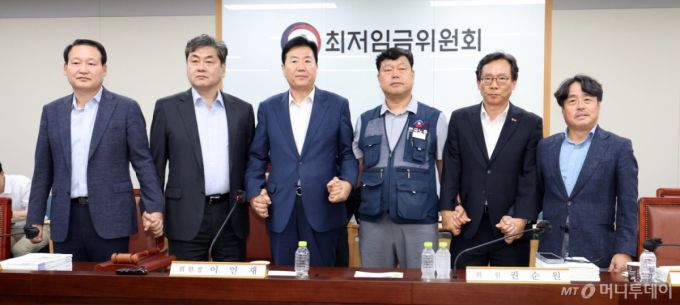 [세종=뉴시스] 강종민 기자 = 최저임금위원회 이인재 위원장과 권순원 공익위원, 류기정 사용자 위원, 류기섭 근로자 위원 등이 지난 10일 밤 세종시 정부세종청사에서 2026년도 적용 최저임금안을 합의로 결정한 뒤 손을 맞잡고 있다.   내년도 최저임금은 1만 320원으로 결정됐다. 2024.07.11. ppkjm@newsis.com /사진=강종민