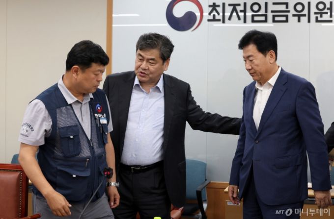 [세종=뉴시스] 강종민 기자 = 최저임금위원회 이인재 위원장이 지난 10일 밤 세종시 정부세종청사에서 2026년도 적용 최저임금안을 합의로 결정한 뒤 류기정 사용자 위원과 류기섭 근로자 위원을 불러 모으고 있다.   내년도 최저임금은 1만 320원으로 결정됐다. 2024.07.11. ppkjm@newsis.com /사진=강종민