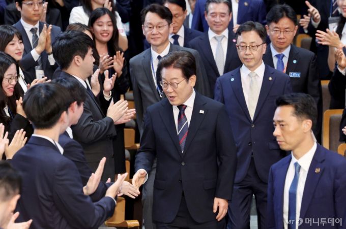 [진천=뉴시스] 최동준 기자 = 이재명 대통령이 14일 5급 신임관리자과정 교육생에게 특강을 하기 위해 충북 진천 국가공무원인재개발원 강당에 입장하며 참석자들과 인사하고 있다. (대통령실통신사진기자단) 2025.07.14. photocdj@newsis.com /사진=최동준