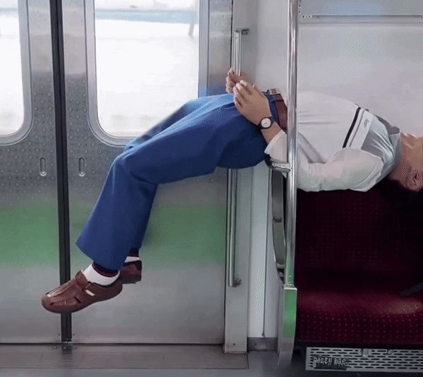 지하철 2호선에서 한 남성이 좌석 손잡이에 허리를 대고 누워 있다. /사진=온라인 커뮤니티