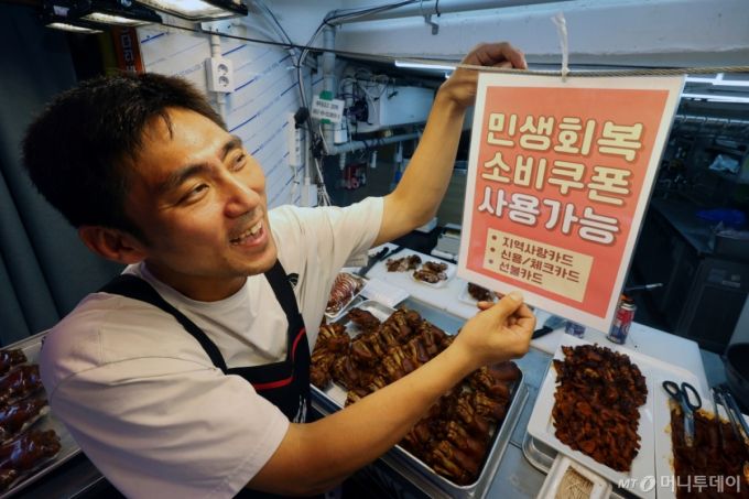 (서울=뉴스1) 황기선 기자 = 민생회복 소비쿠폰 1차 신청 첫 날인 21일 서울의 한 족발전문점에서 상인이 쿠폰 사용 관련 안내문을 붙이고 있다. 2025.7.21/뉴스1  Copyright (C) 뉴스1. All rights reserved. 무단 전재 및 재배포,  AI학습 이용 금지. /사진=(서울=뉴스1) 황기선 기자