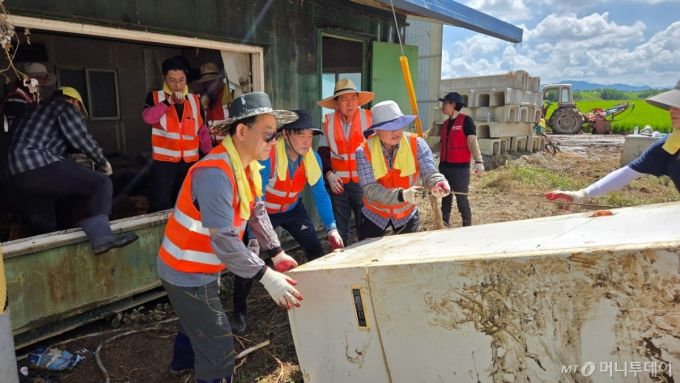 22일 충남 예산을 찾아 수해 복구 봉사활동에 나선 국민의힘 의원들이 수마에 휩쓸린 냉장고 등 잔해를 치우고 있다.사진=박상곤 기자