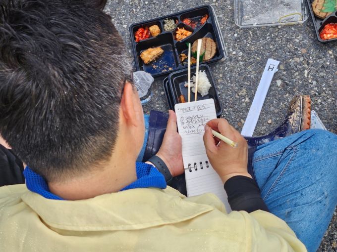 박찬대 더불어민주당 대표 후보가 지난 21일 폭우 피해를 입은 시민의 요청 사항을 메모하고 있다./사진=이승주 기자.